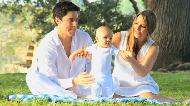 Pareja joven jugando con el bebé en el parque — Vídeos de Stock