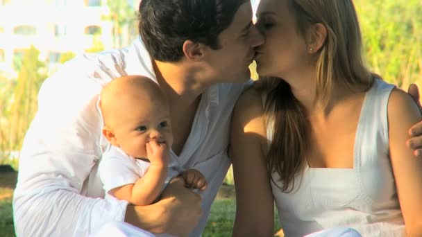 Young couple kissing with baby in her arms — Stock Video