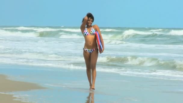 Chica con tabla caminando en la playa — Vídeo de stock