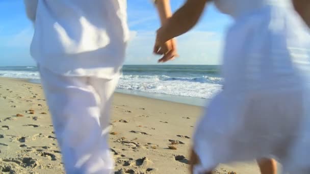 Familia vestida de blanco disfrutando del tiempo caminando playa — Vídeo de stock