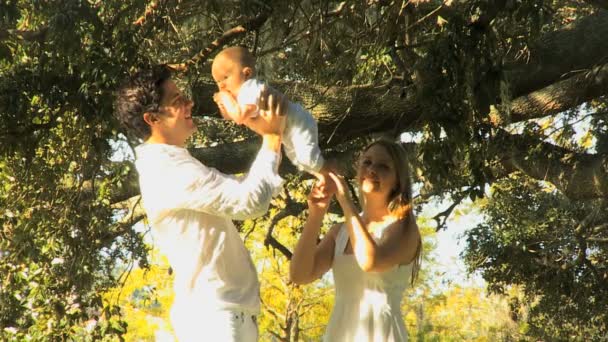 Junges Paar spielt mit Baby im Park — Stockvideo