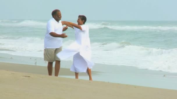 Pareja étnica mayor bailando descalza en la playa — Vídeo de stock