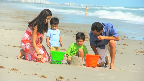 Jonge Spaanse familie spelen zand strand uitje — Stockvideo