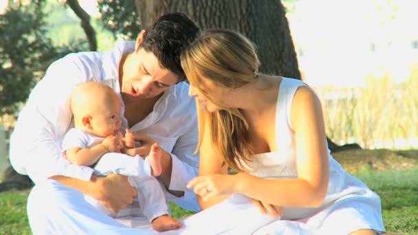 Pareja joven jugando con el bebé en el parque — Vídeos de Stock