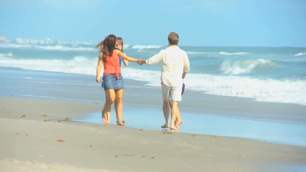 Feliz família caucasiana correndo areia molhada na praia — Vídeo de Stock