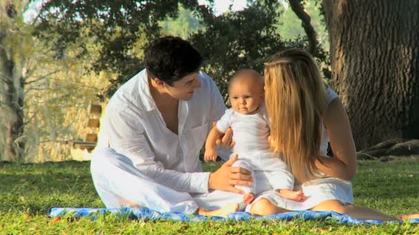 公園で赤ちゃんと遊ぶ若いカップル — ストック動画