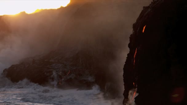 Red hot lava falling over barren landscape into ocean — Stock Video