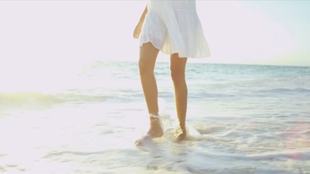 Ноги ногами дівчина, що йде мілководді океану — стокове відео