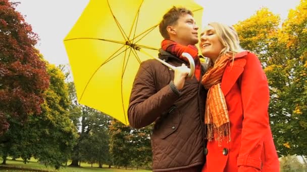 Couple sheltering from weather in the park — Stock Video