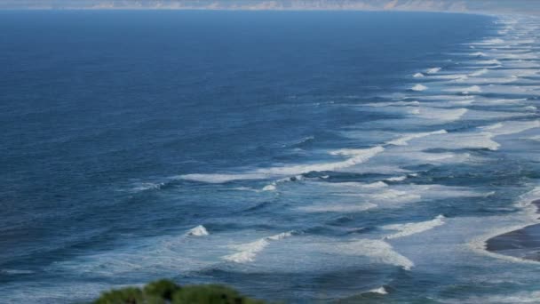 Над пляжем кружатся океанские волны — стоковое видео