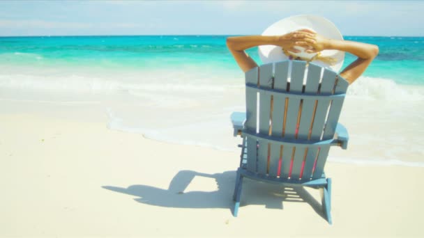 Jovem fêmea chapéu de sol relaxante cadeira de praia — Vídeo de Stock