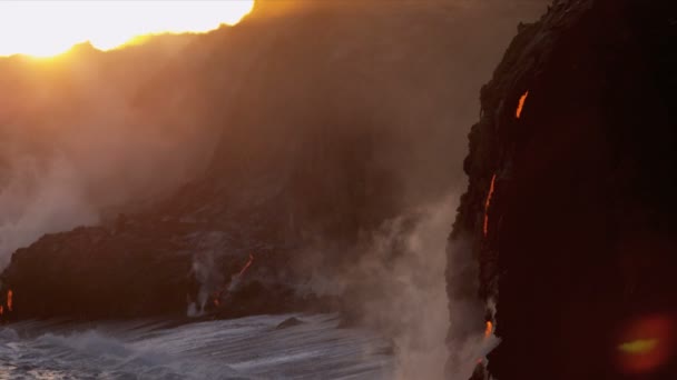 Red hot lava falling over barren landscape into ocean — Stock Video