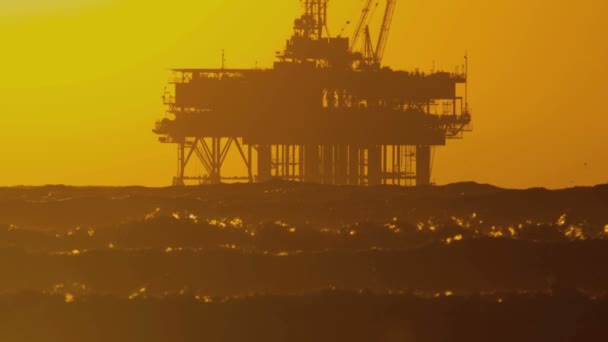 Plate-forme pétrolière dans la mer au coucher du soleil — Video