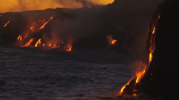 Vapor de lava fluye junto a rocas costeras — Vídeo de stock
