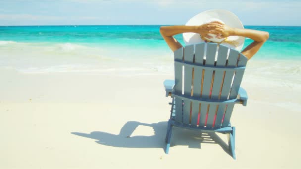 Dziewczyna, opalając się na drewnianym krześle na tropikalnej plaży — Wideo stockowe