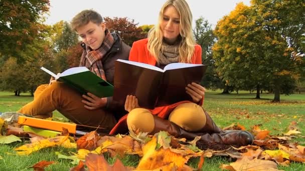 Студенческая пара пересматривает заметки Осенний день — стоковое видео
