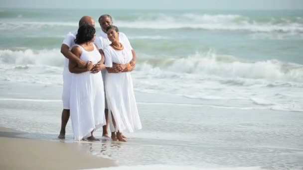 Старші етнічні пари насолоджуються часом на пляжі — стокове відео