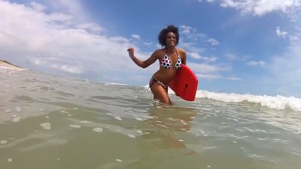 Mujer caminando en el mar con el tablero del cuerpo — Vídeo de stock