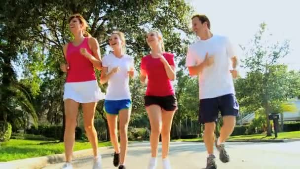 Föräldrar med unga tonåriga döttrar jogging — Stockvideo
