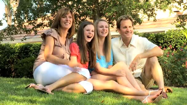 Föräldrar med teenage döttrar sitter på gräset — Stockvideo