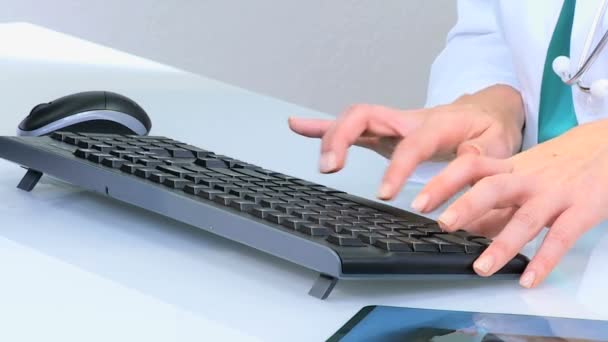 Female doctor typing on computer keyboard — Stock Video