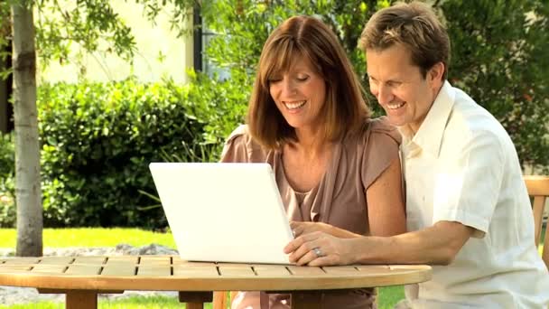 Paar thuis tuin met laptop — Stockvideo