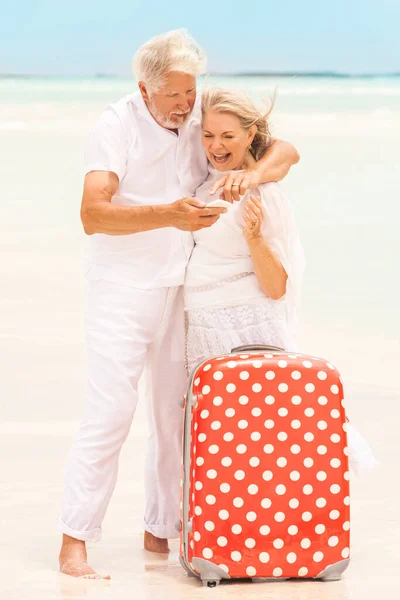 Senior Caucasian Couple Barefoot Caribbean Beach Together Red Suitcase Taking — Foto de Stock