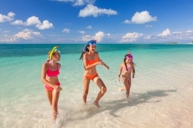 Young American Caucasian siblings in swimwear and snorkel equipment by the aquamarine ocean shallows on tranquil tropical island Caribbean beach travel clipart