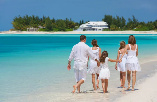 カリブ海の海で熱帯のビーチを歩く白いドレスで一緒に幸せな若い白人の家族 — ストック写真