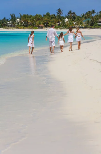 Happy Caucasian family white clothes walking tropical beach