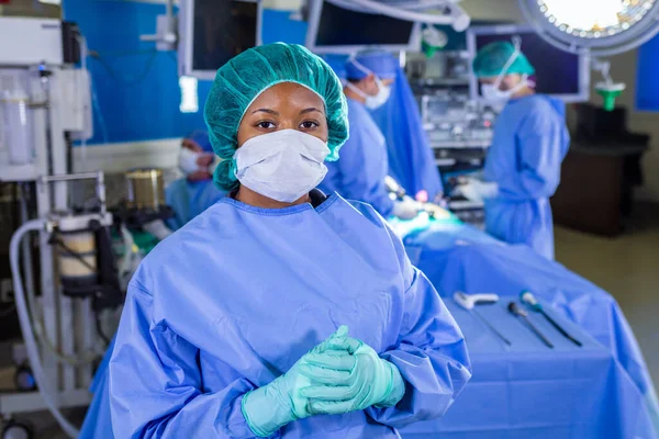 Portrait of African American female medical healthcare frontline doctor in hospital PPE sterile scrub face mask gloves working in patient operating theatre