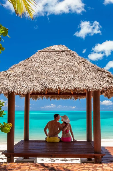 Loving Caucasian male and female couple in tropical tiki enjoying leisure and holiday on the beach outdoor Caribbean