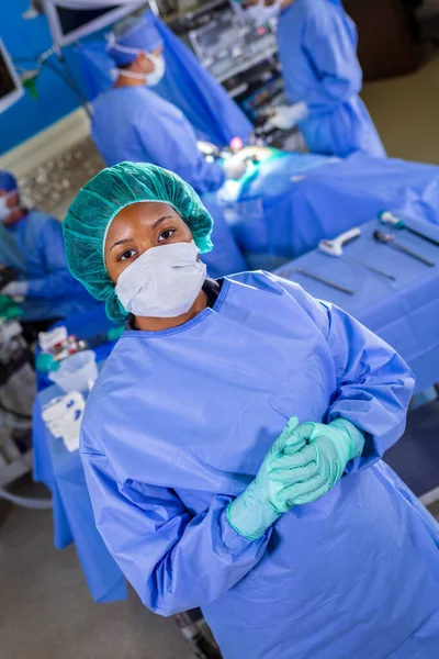 Portrait of African American female medical healthcare frontline nurse in hospital PPE sterile scrub face mask gloves working in patient operating theatre