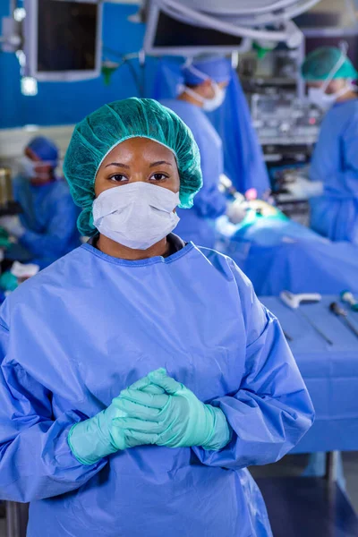 Portrait of African American female medical healthcare frontline nurse in hospital PPE sterile scrubs face mask gloves working in patient operating theatre