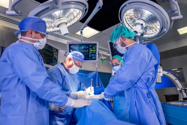 在医院手术室 专家外科小组戴着口罩手套和长袍 对病人进行腹腔镜检查 — 图库照片
