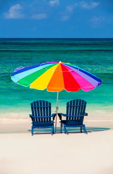 Bahamas vacation resort beach sun loungers with colorful umbrella on golden sand aquamarine ocean Gulf of Mexico Caribbean Sea USA