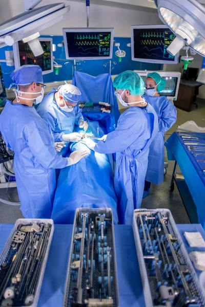带个人防护装备的白人医疗小组在医院手术室实施整形外科的医疗器械 — 图库照片