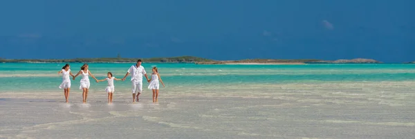View of panorama Caucasian mother father with family holding hands walking sand barefoot enjoying leisure on their tropical beach holiday Bahamas