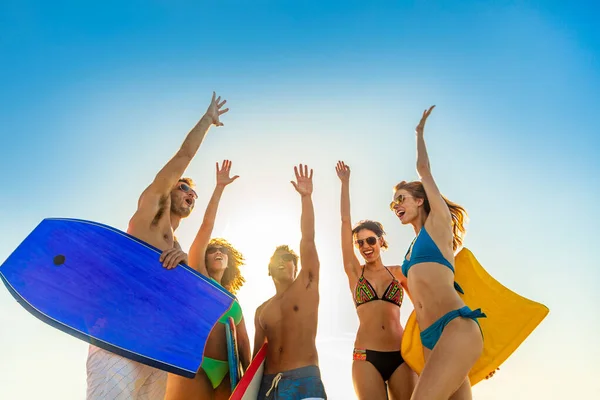 Happy Friends Swimwear Carrying Bodyboards Arms Raised Celebrating Fun Activity — ストック写真