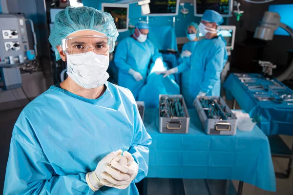 医院手术室 由外科小组配戴刷子 用消毒过的医疗器械对麻醉病人进行手术 图库图片