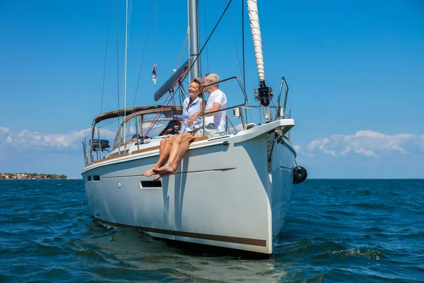 Adventurous senior American couple sailing the ocean on luxury yacht enjoying healthy retirement relaxing outdoors after successful life