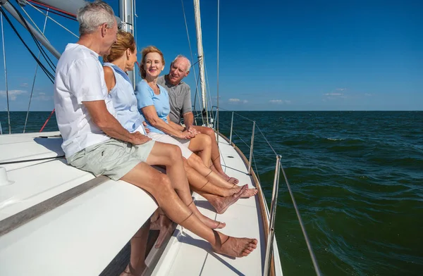 Luxury Summer vacation for retired group of friends sitting together on private yacht enjoying freedom sailing the ocean