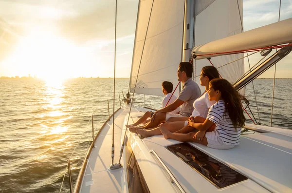 Carefree family travel adventures for young Latino parents with son and daughter relaxing on luxury yacht at sunset