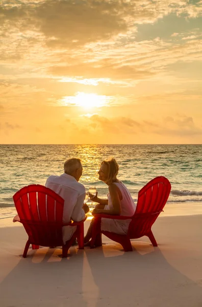 熱帯の休暇を楽しむワインのガラスとリラックスした日没で海に座っているシニア白人カップルを愛するバハマ — ストック写真