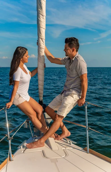 Travel loving Latino couple with luxury lifestyle having fun on relaxing sailing vacation sitting together on private yacht