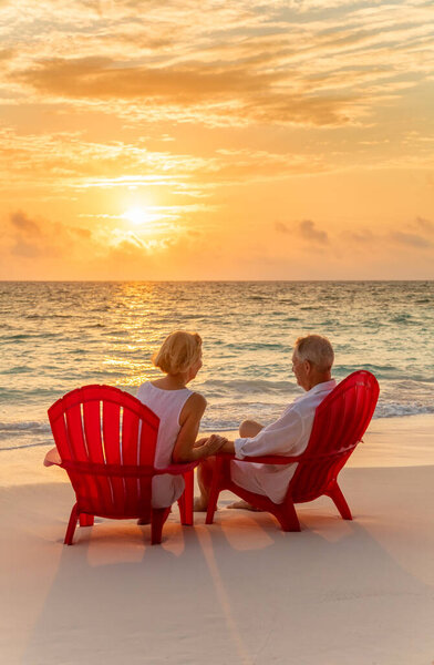 Loving Seniors Wearing White Casual Clothing Relaxing Red Chairs Watching Royalty Free Stock Photos