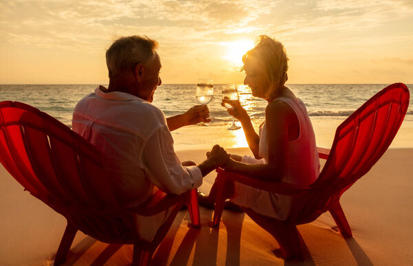 Loving Retired Caucasian Couple Enjoying Togetherness Beach Vacation Drinking Wine Royalty Free Stock Images