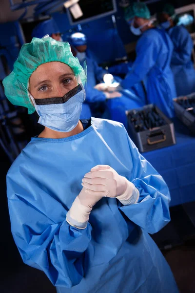 医院手术室女白种人护士头戴外科口罩和手套的肖像 图库照片