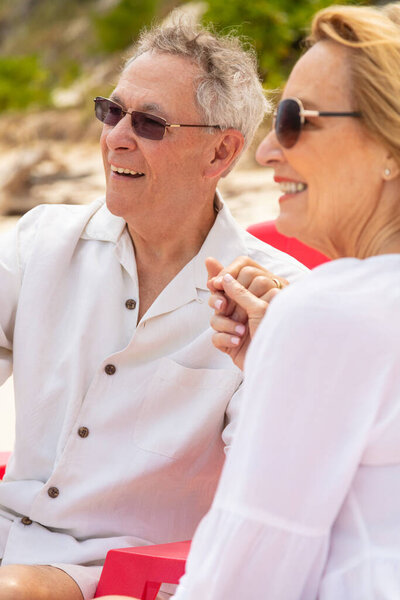 Happy Retired Caucasian Couple White Casual Clothing Sunglasses Sitting Together Stock Photo
