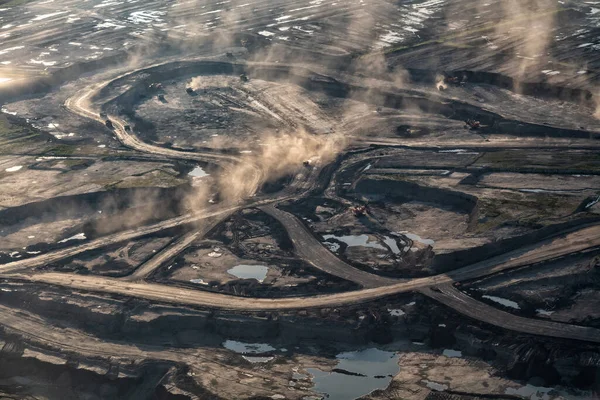 Aerial view of blackened Tar sands Ft McMurray surface pit mining of Oilsands on an Industrial scale refined by Petrochemical Plants Alberta travel